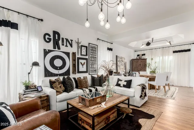 a living room with furniture a chandelier and a flat screen tv