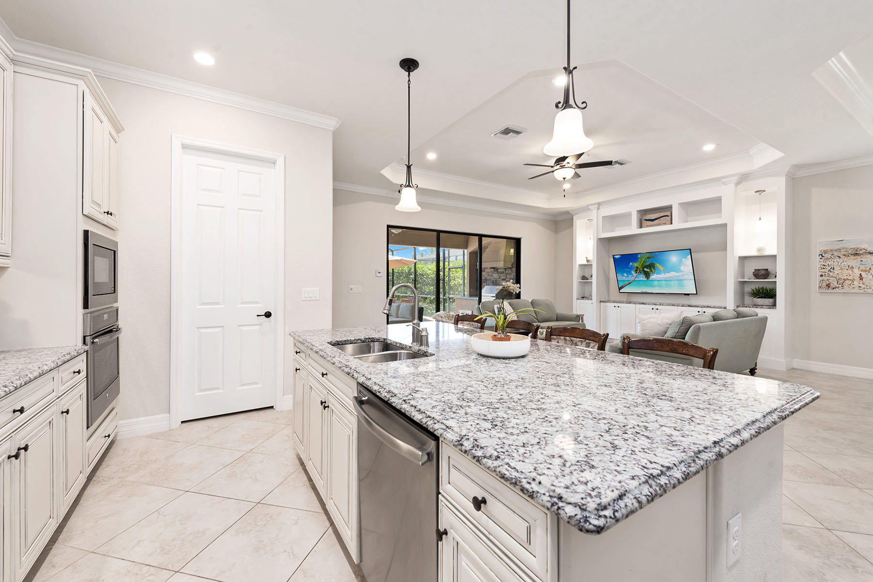 3009 Aviamar Circle Naples, FL 34114 - Photo 7 of 50 a view of a kitchen counter kitchen island granite countertop wooden floor center island a refrigerator and a counter space