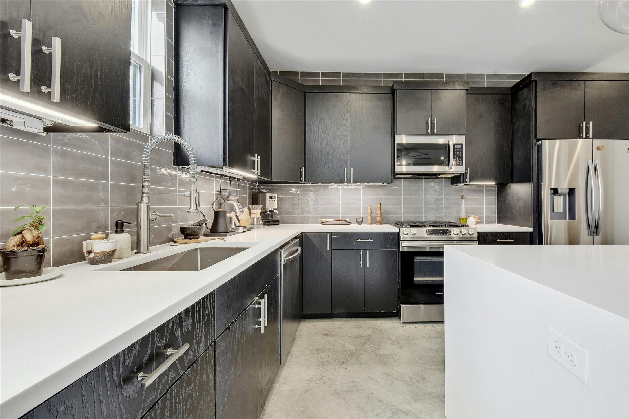 4606 Ledesma Road, Unit 2 Austin, TX 78721 - Photo 14 of 33 A well-appointed culinary space featuring sleek cabinetry, quartz countertops, and modern stainless steel appliances.