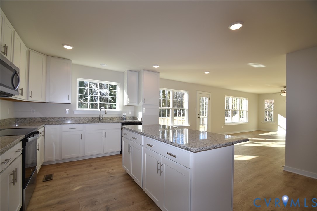 7014 Woodside Street Henrico, VA 23231 - Photo 3 of 13 a kitchen with stainless steel appliances granite countertop a sink and stove