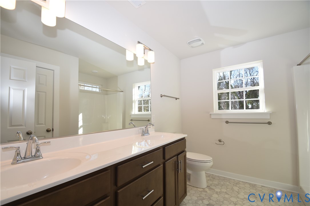7014 Woodside Street Henrico, VA 23231 - Photo 9 of 13 a bathroom with a sink a toilet a mirror and window