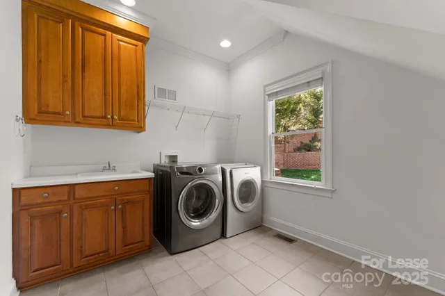 a utility room with sink dryer and washer