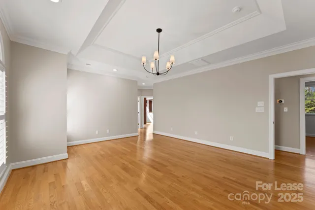 a view of empty room with wooden floor and ceiling fan