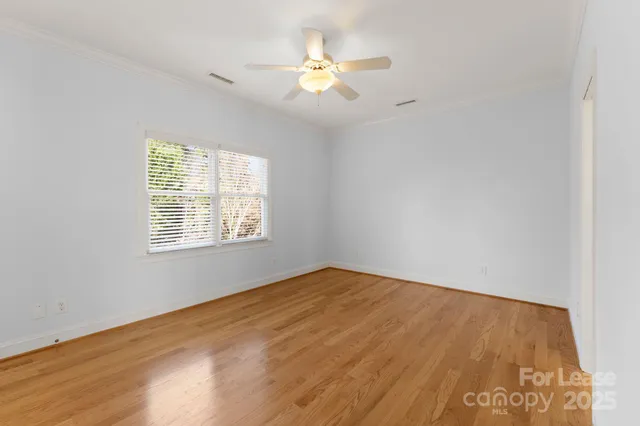 an empty room with a window and a ceiling fan