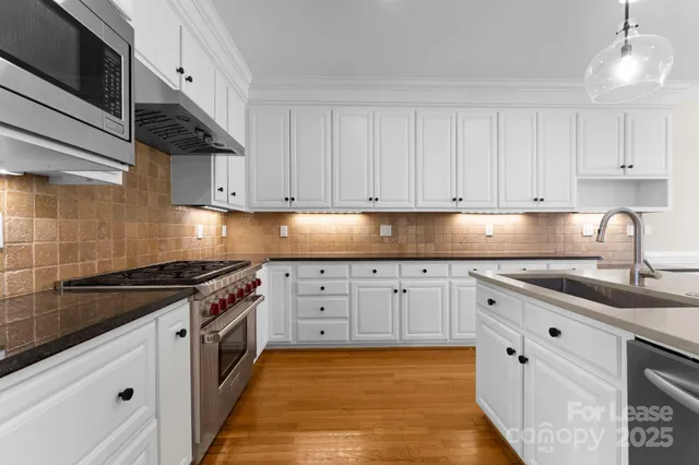 a kitchen with granite countertop a sink stove and cabinets