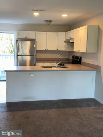 a kitchen with stainless steel appliances granite countertop a sink a stove a refrigerator a microwave and cabinets