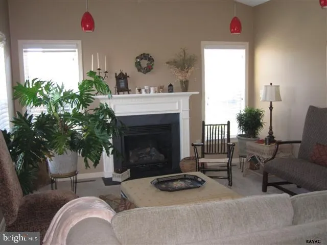 a living room with furniture a large window and a fireplace