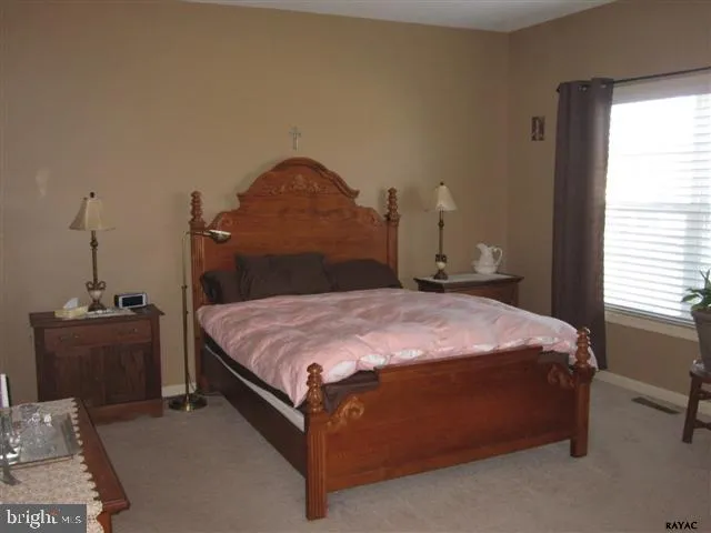 a bed sitting in a bedroom next to a window