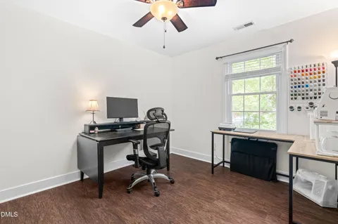 a view of a workspace with furniture and a window