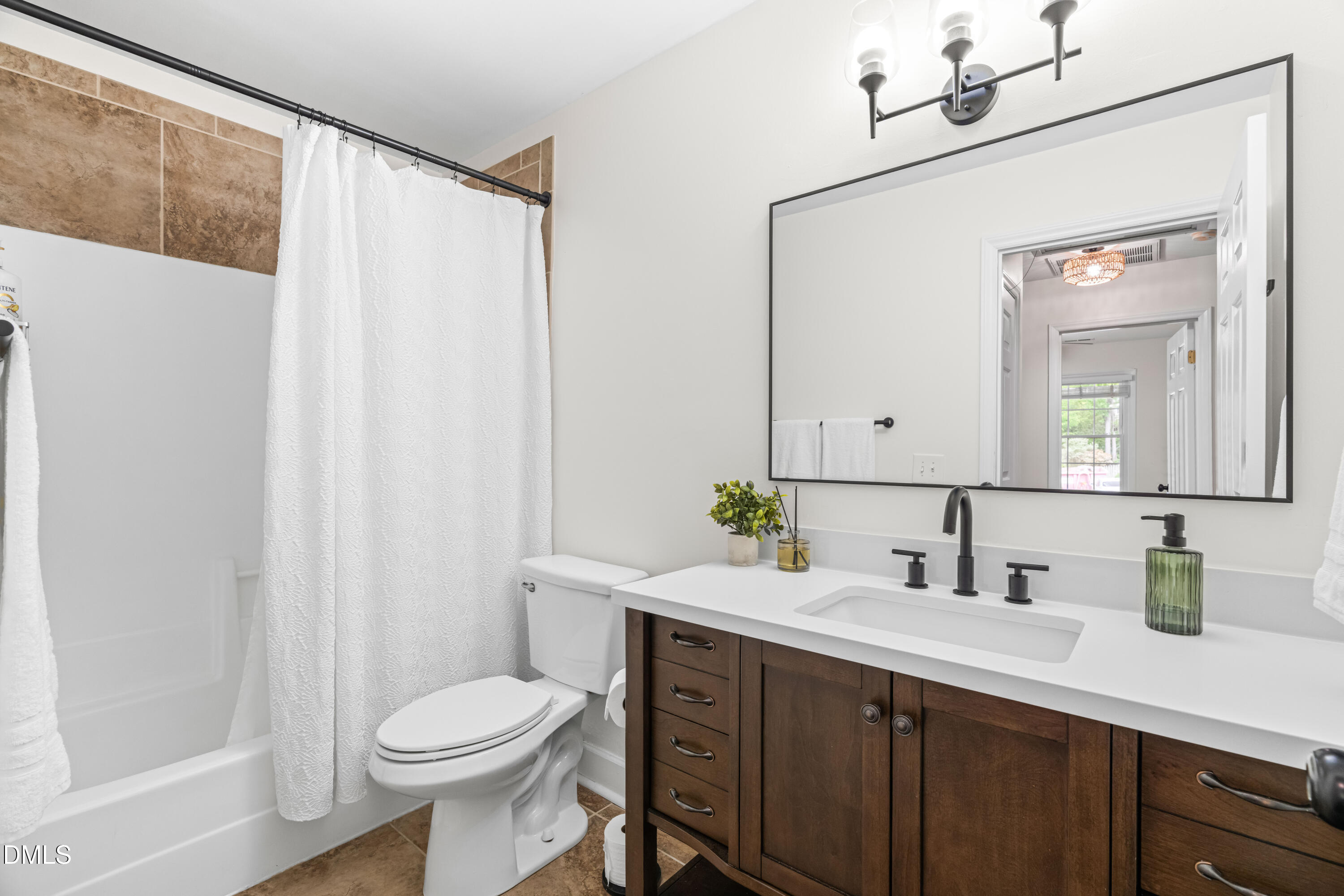 1109 Theresa Court Raleigh, NC 27615 - Photo 20 of 39 a bathroom with a sink a toilet and mirror