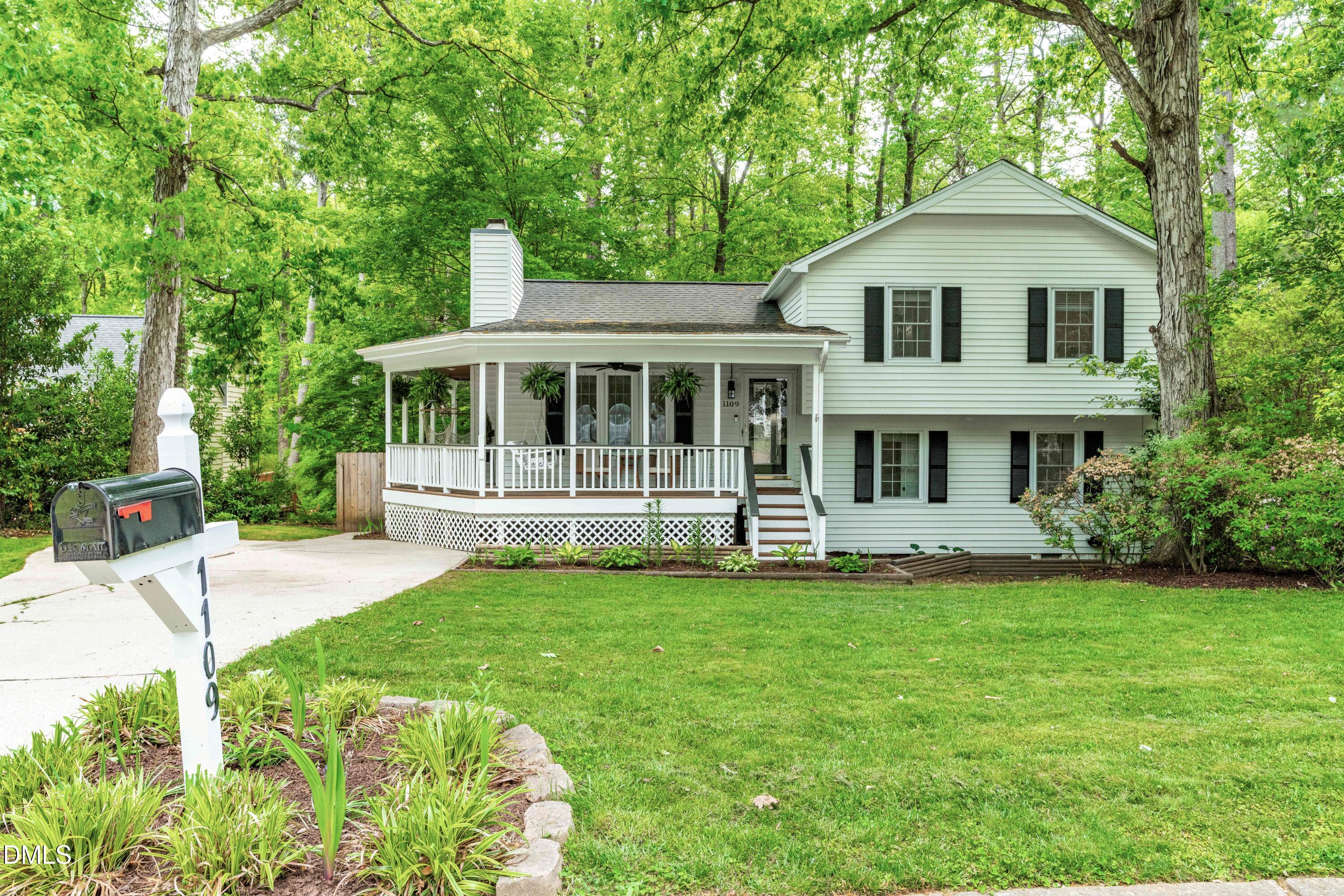 1109 Theresa Court Raleigh, NC 27615 - Photo 2 of 39 a white house that has a big yard with plants and trees