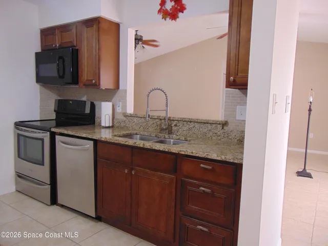 a kitchen with stainless steel appliances granite countertop a sink stove and microwave