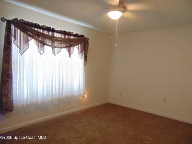 a view of a hallway with a window and chandelier