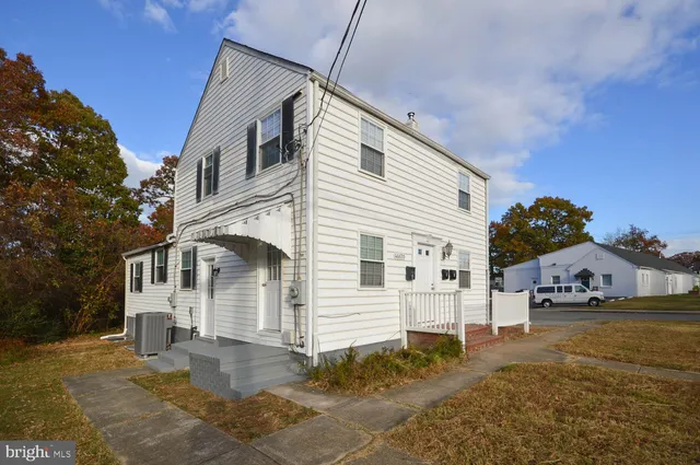 a view of a white house with a yard