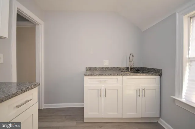 a bathroom with a granite countertop sink and a vanity