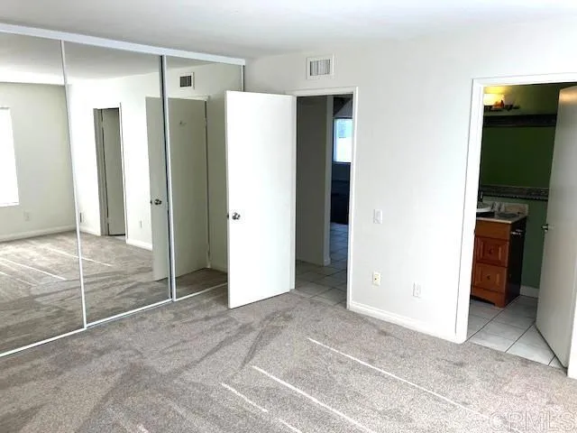 a view of a kitchen with refrigerator and an empty room