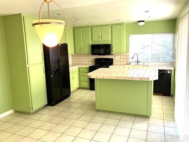 a kitchen with stainless steel appliances kitchen island granite countertop a refrigerator a stove and a microwave