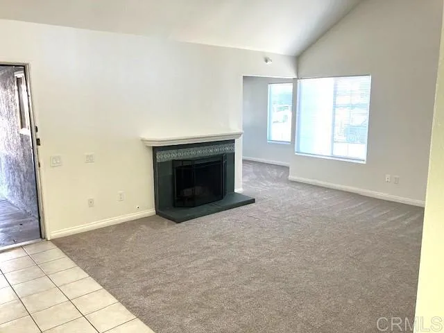 an empty room with windows and fireplace