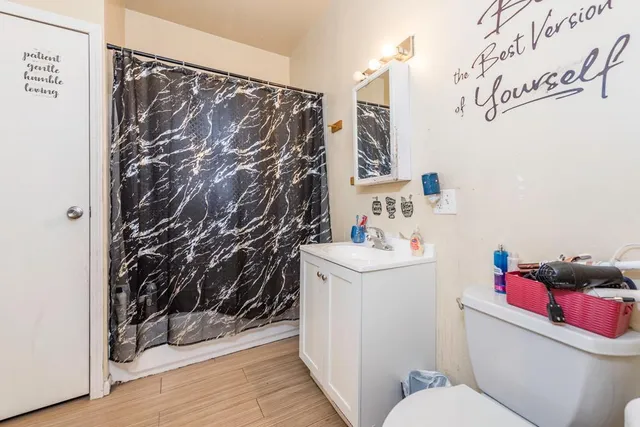 a bathroom with a toilet and a shower curtain