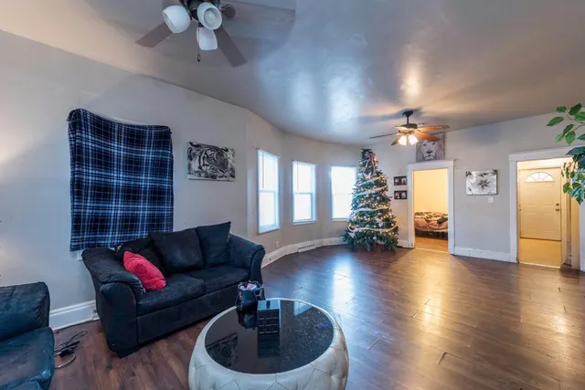 a living room with furniture and a wooden floor