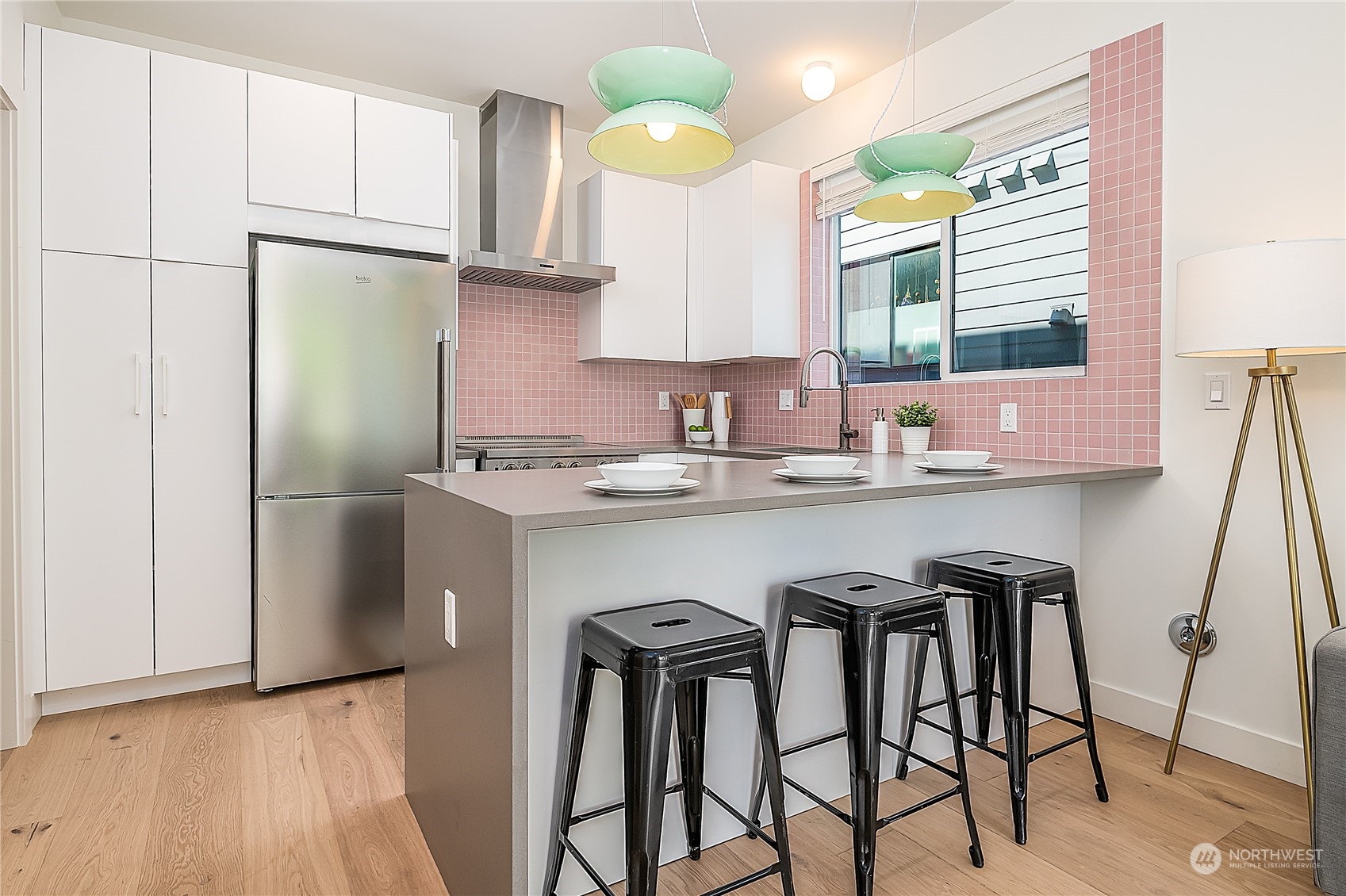 916 North 100th Street, Unit B Seattle, WA 98133 - Photo 5 of 19 a kitchen with stainless steel appliances granite countertop a sink a stove a refrigerator and island with wooden floor