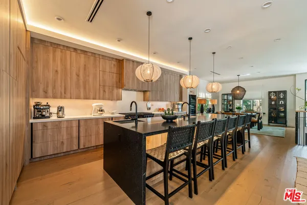 a kitchen with lots of wooden furniture appliances and cabinets
