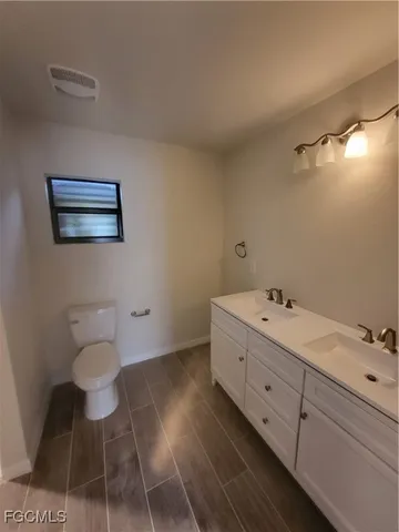a bathroom with a sink mirror and toilet