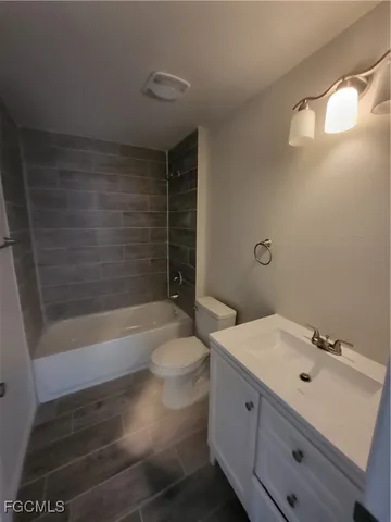 a bathroom with a bathtub shower sink vanity and toilet