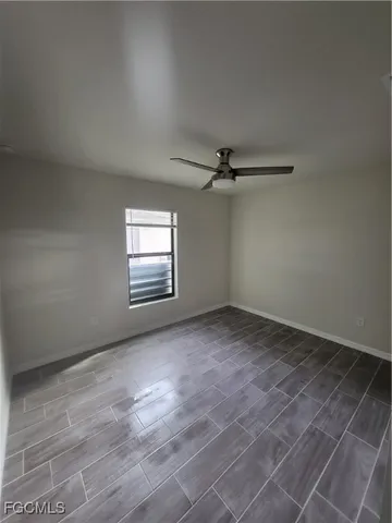 an empty room with windows and fan