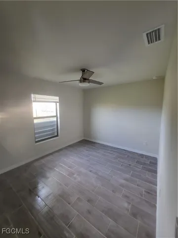 en empty room with windows and ceiling fan