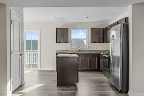 a kitchen with a refrigerator and a stove top oven