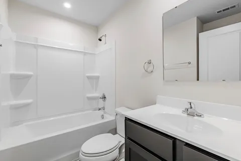 a bathroom with a granite countertop sink a toilet and shower