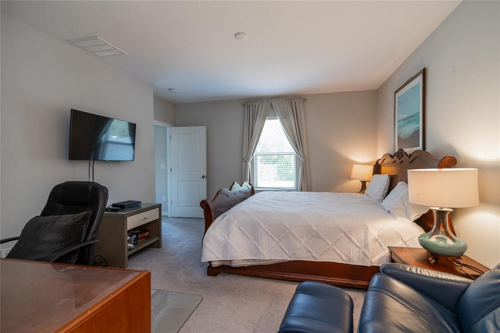 5127 Sable Chime Drive Wimauma, FL 33598 - Photo 21 of 56 a bedroom with a bed and a lamp on dresser