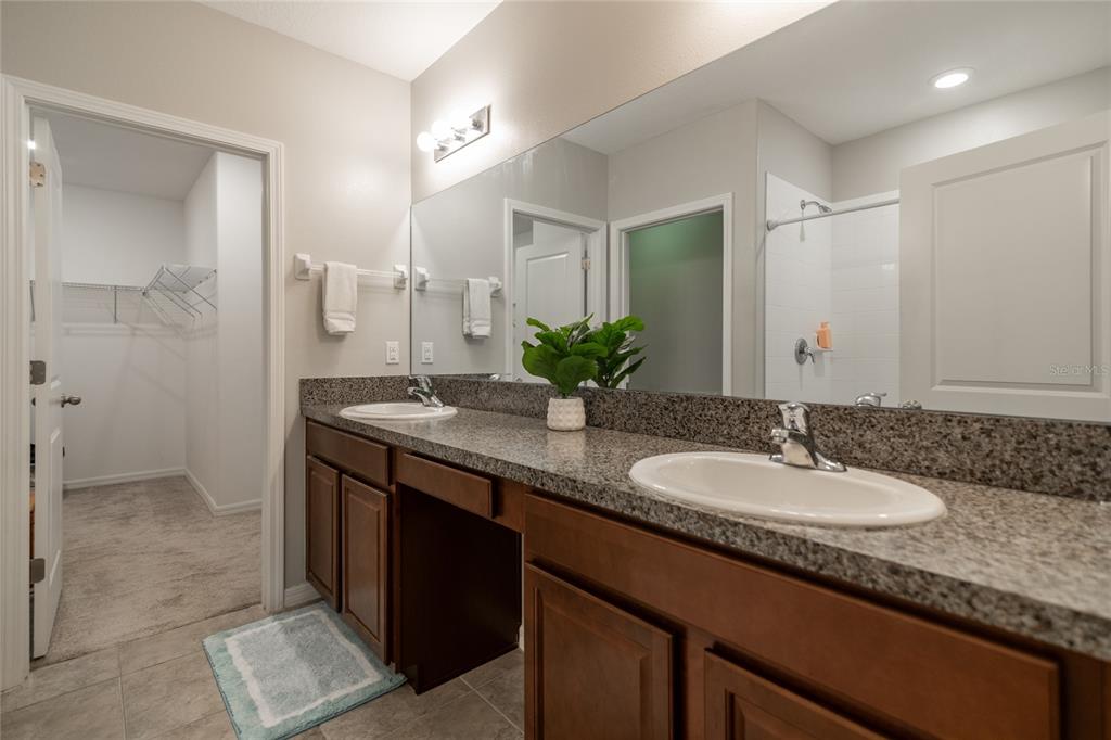 5127 Sable Chime Drive Wimauma, FL 33598 - Photo 22 of 56 a bathroom with a granite countertop sink and a mirror