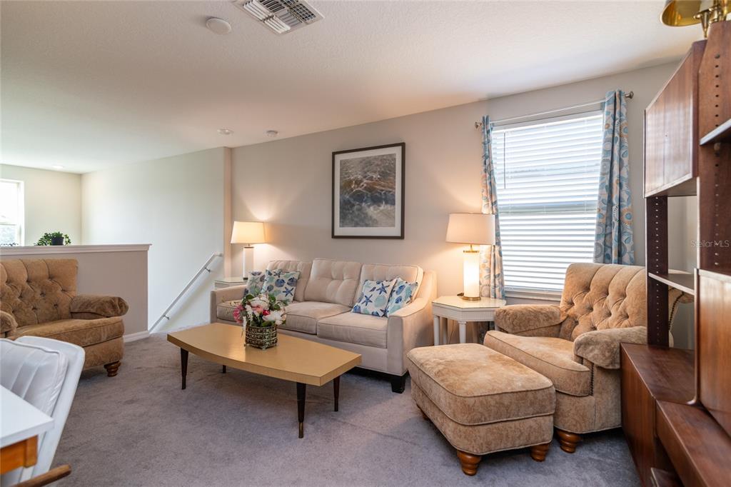 5127 Sable Chime Drive Wimauma, FL 33598 - Photo 28 of 56 a living room with furniture a lamp paintings and a window