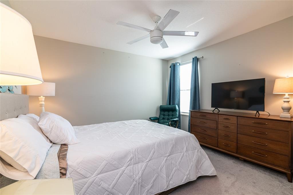 5127 Sable Chime Drive Wimauma, FL 33598 - Photo 30 of 56 a bedroom with a large bed and a flat screen tv