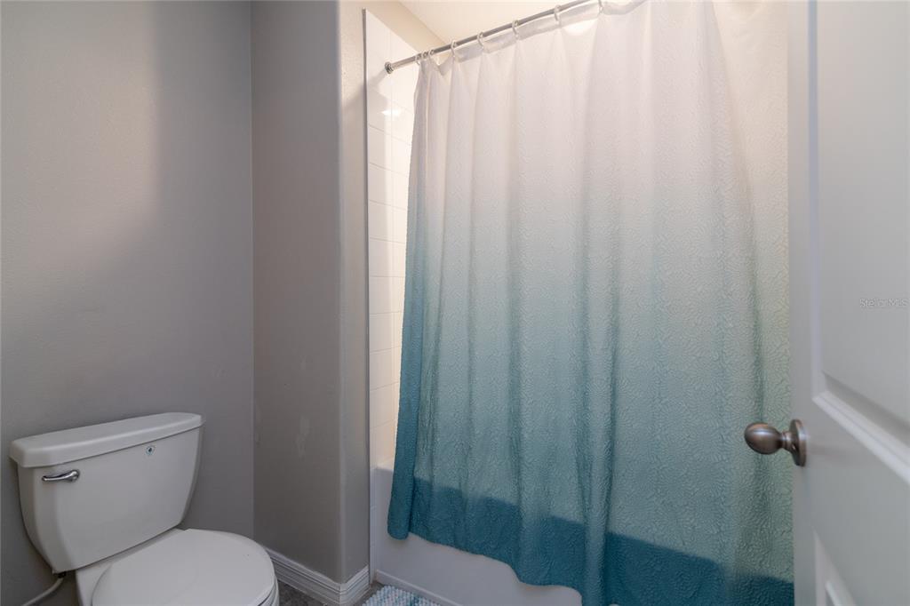 5127 Sable Chime Drive Wimauma, FL 33598 - Photo 33 of 56 a white toilet sitting next to a shower curtain