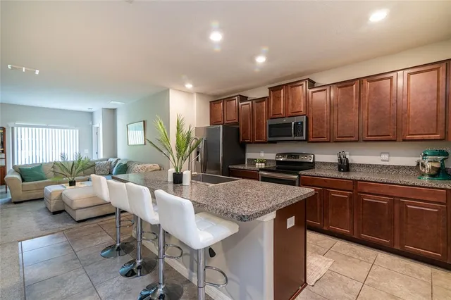 a large kitchen with granite countertop lots of counter top space and stainless steel appliances