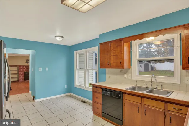 an empty room with wooden floor chandelier and windows