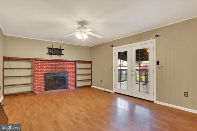 an empty room with a hardwood and ceiling fan