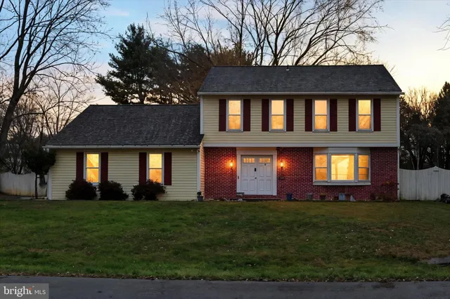 a brick building sitting in front of a big yard with potted plants