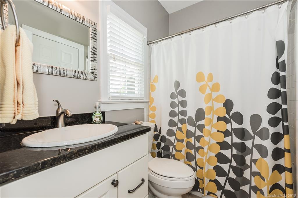 3310 Blue Jay Pass Fort Mill, SC 29708 - Photo 24 of 40 a bathroom with a granite countertop sink toilet a mirror and shower curtain