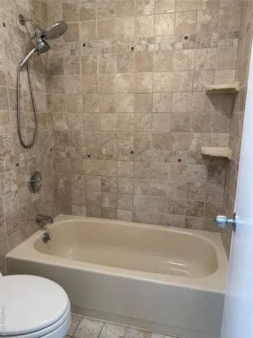 a bathroom with a toilet bathtub and shower