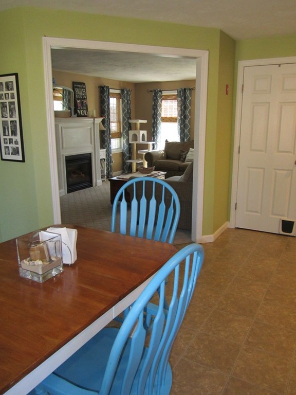 3 A Oakham Road North Brookfield, MA 01535 - Photo 11 of 26 a view of a livingroom with furniture a fireplace wooden floor and a kitchen view