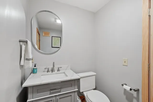 a bathroom with a toilet a sink and mirror