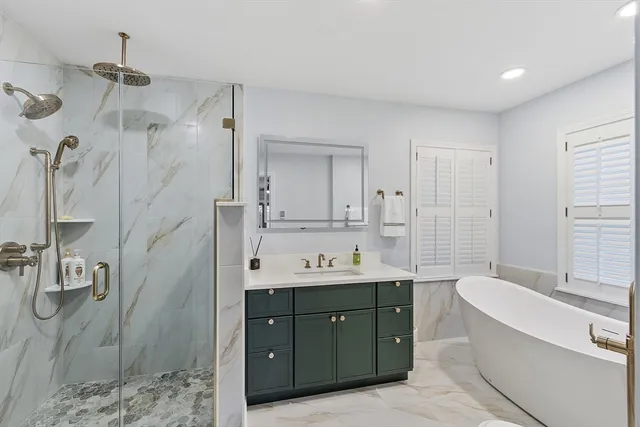 a bathroom with a tub sink double vanity granite and shower