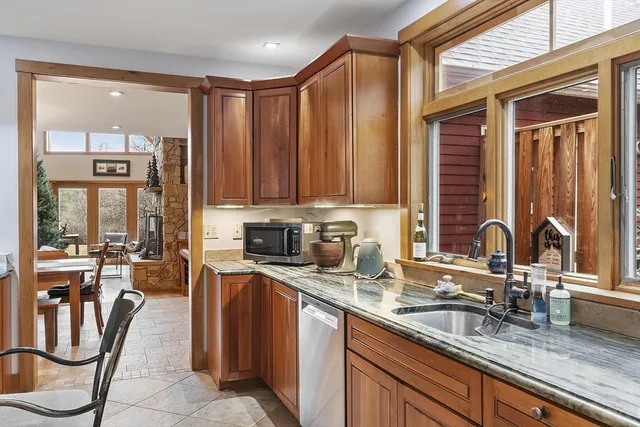 a kitchen with kitchen island granite countertop a sink counter top space appliances and cabinets
