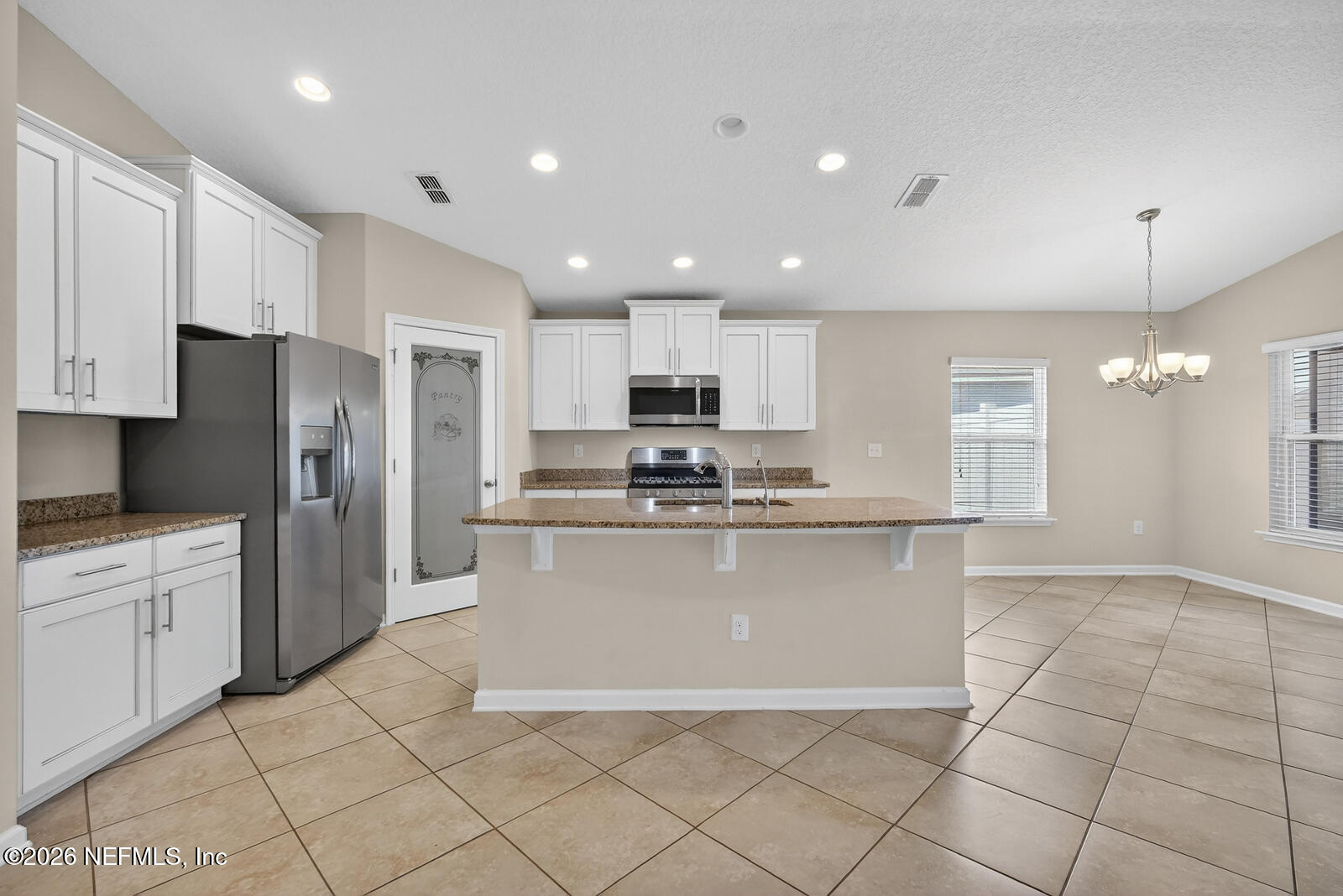 353 Green Turtle Lane St. Augustine, FL 32086 - Photo 19 of 48 a kitchen with stainless steel appliances granite countertop a refrigerator a sink a stove a microwave and island