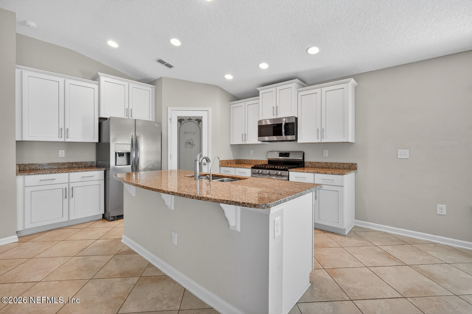 353 Green Turtle Lane St. Augustine, FL 32086 - Photo 21 of 48 a kitchen with kitchen island granite countertop a stove sink and cabinets