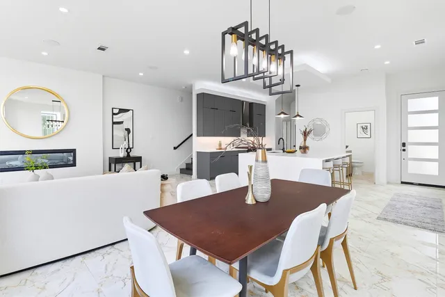 a dining room with wooden floor a chandelier a wooden table and chairs